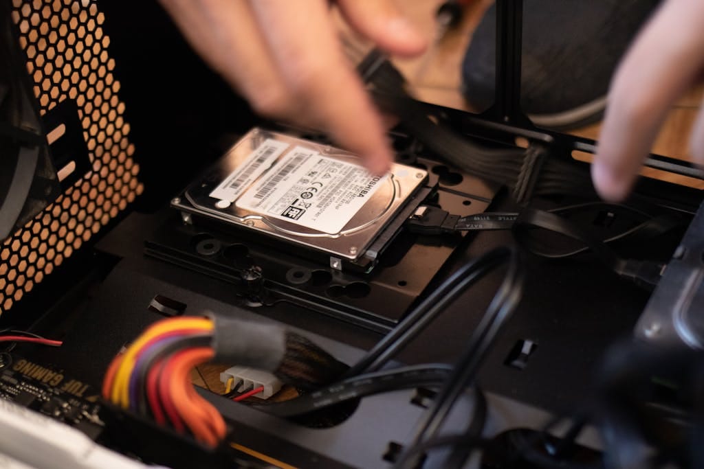 Close-up of hands replacing a laptop hard drive during repair at No Fuss Computers