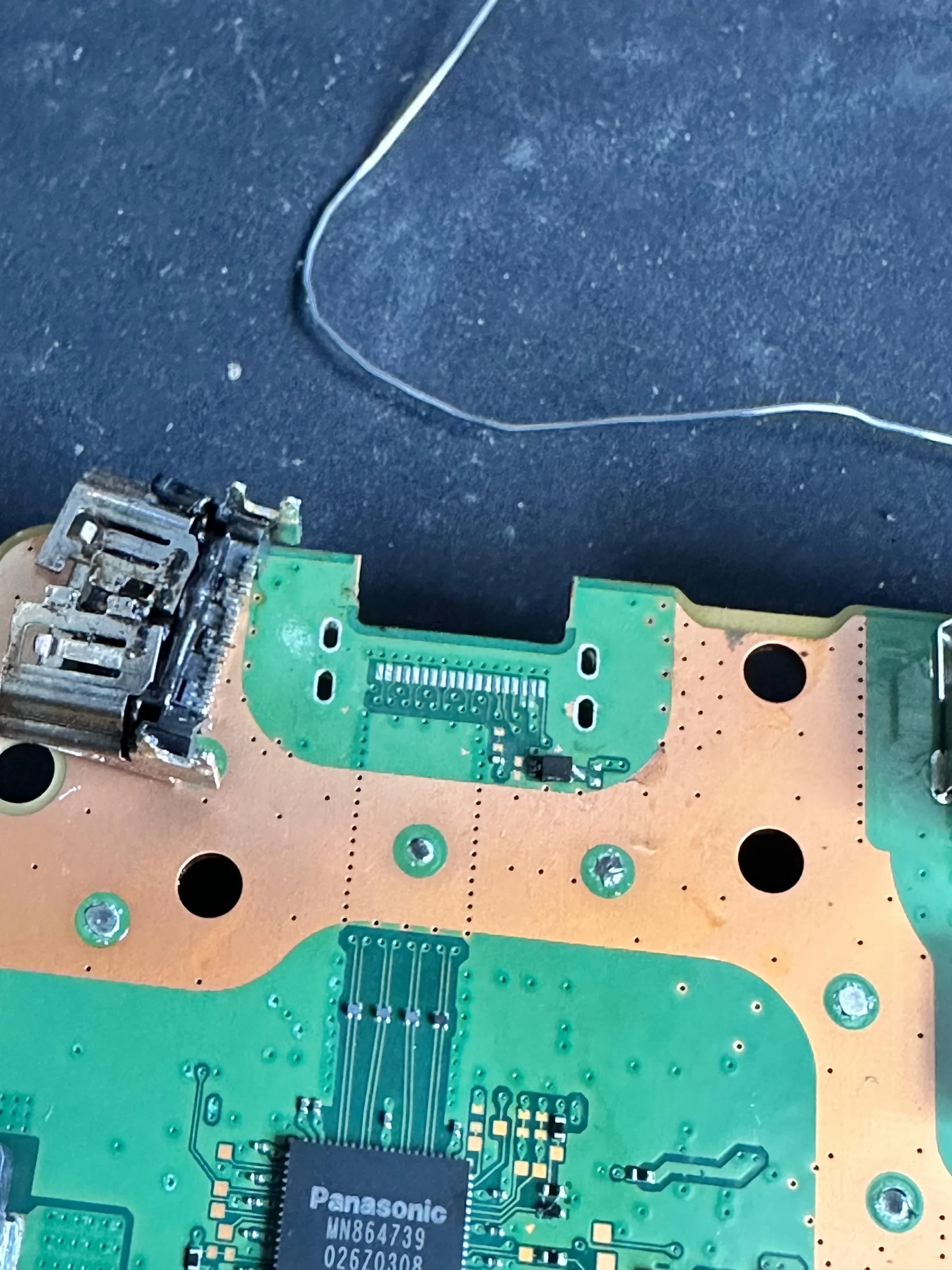 PS5 motherboard HDMI pads lifted from the board under microscope